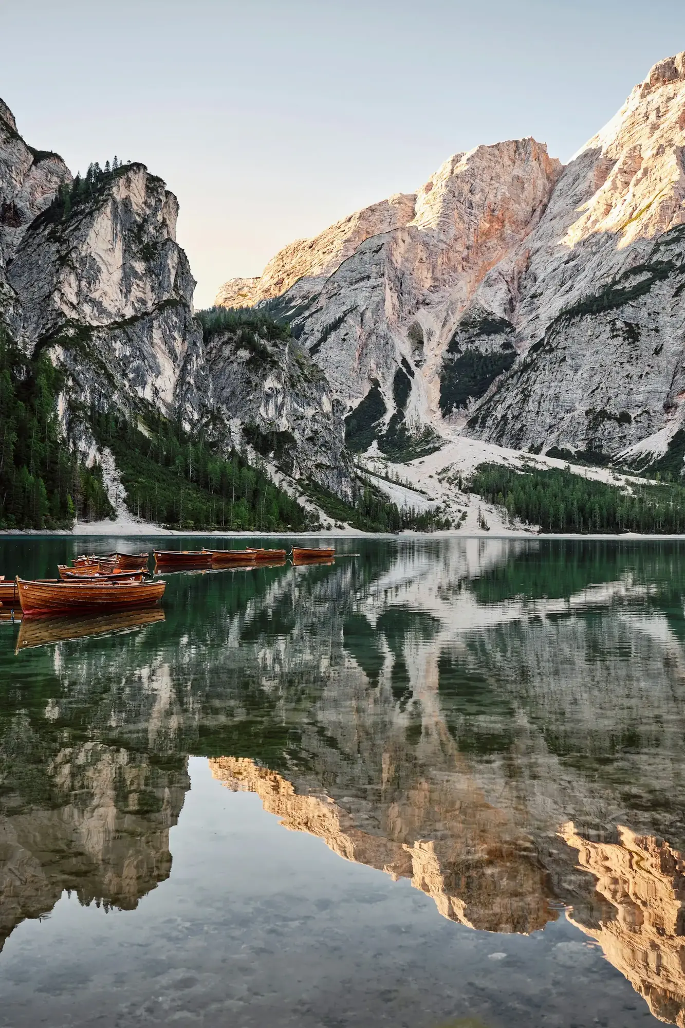 Montagne e boschi si riflettono nelle acque di un lago delle Dolomiti